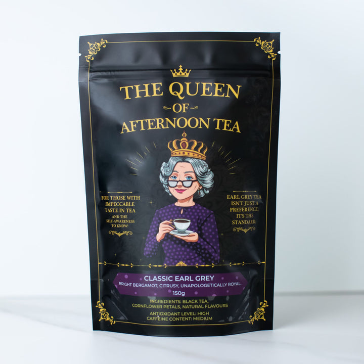 Translation missing: en.A black stand-up pouch of 'The Queen of Afternoon Tea' Classic Earl Grey tea, featuring a gold crown and gold lettering, with an illustration of an elderly queen in a purple dress holding a teacup